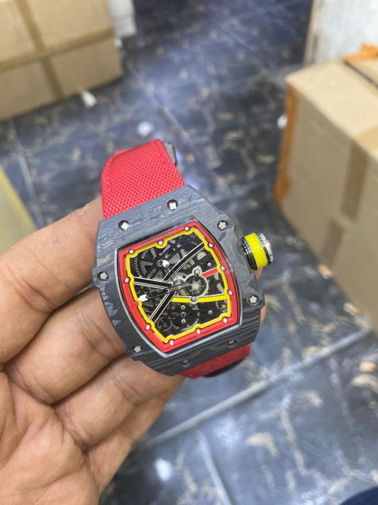 RM 67-02 — held in hand, angled view showing the case and red strap