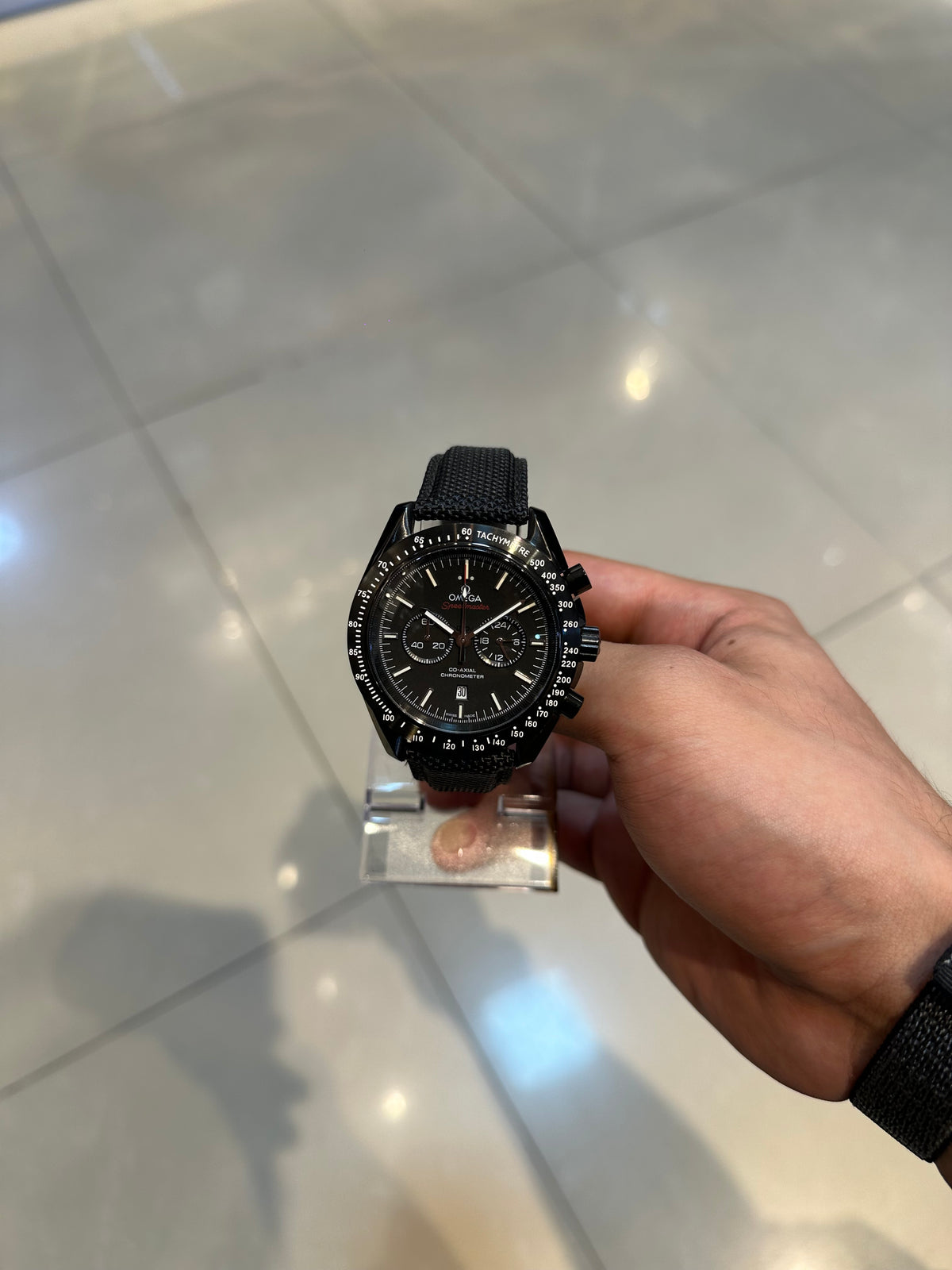 Speedmaster, black dial — held in hand, showing size